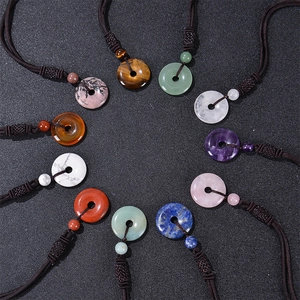 Collection of natural tiger eye and crystal stone donut pendant necklaces on woven cords