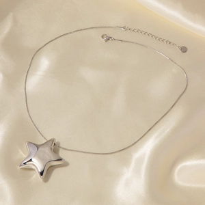 Silver star pendant necklace on champagne silk fabric with minimalist snake chain