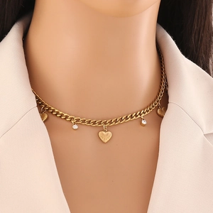 Collier gourmette doré avec pendentifs cœur et strass porté par un mannequin femme