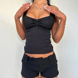 Detail of black lace halter top with open back and slim fit cropped design