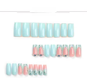 Detail view of blue and pink press-on nails with glitter, rhinestones and french tips