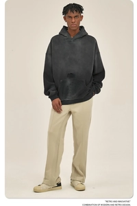 Volledige lichaamsopname van een model met een grijze gewassen hoodie en beige broek