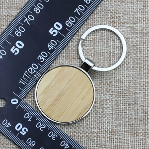 Macro view of round bamboo and silver metal keychain with a measuring ruler
