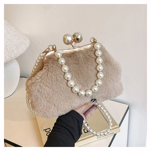 Detailed view of plush faux fur shell bag featuring pearl top handle and clip closure
