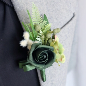 Elegant dark green PE rose wedding boutonniere with silk leaves on a grey suit jacket