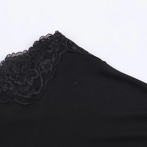 Detaillierte Nahaufnahme der schwarzen Spitzenelemente an einem One-Shoulder-Kleid