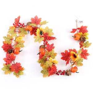 Detail of autumn vine with maple leaves, pumpkins, sunflowers, pine cones and LED lights