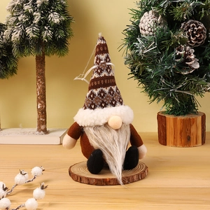 Detail of a Christmas gnome ornament with knitted hat on a natural wood base