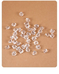 Top view of clear acrylic crushed ice pieces scattered on brown craft paper background