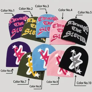 Detail view of colorful knit beanies featuring gothic lettering and star jacquard patterns