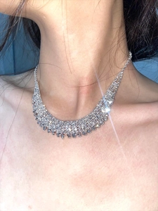 Close-up of sparkling silver tassel necklace with rhinestones on a female model