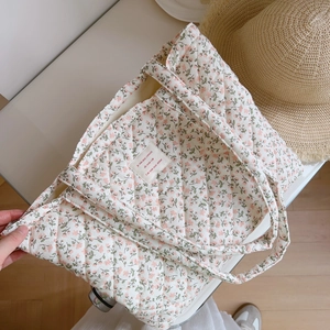 Close-up of pink floral quilted tote bag with soft texture and chic French fabric label