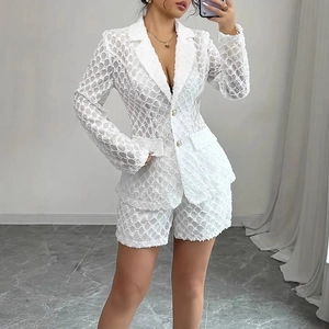 Detail of elegant white hollow jacquard fabric texture on a two-piece blazer and shorts set