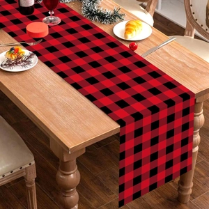 Detail of red and black plaid Christmas table runner on a festive dining table