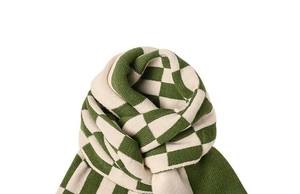 Macro texture of green and beige checkerboard knit scarf with soft thick wool fibers