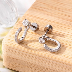 Polished silver U-shaped zirconia earrings with screw back design on wood block