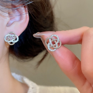Boucles d'oreilles fleur en argent avec oxydes de zirconium et design de nœud tissé