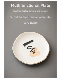 Detail of white ceramic jewelry tray with gold rim and Love heart design