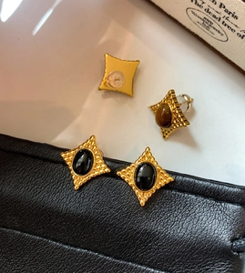 Détails rapprochés des boucles d'oreilles vintage avec pierres œil de tigre ovales
