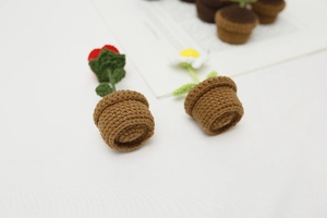 Close-up of handmade crochet potted roses and daisies with detailed woven texture