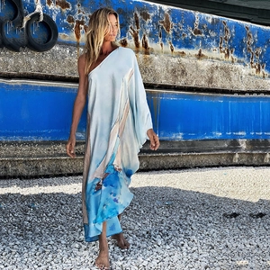 Detail eines hellblauen Maxikleids mit One-Shoulder-Design und Segelboot-Druckmuster
