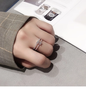 Close-up of stacked silver and rose gold rings with rectangular stones and pavé diamonds