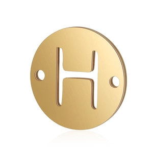Close-up of golden stainless steel double-hole round pendant with hollow letter H detail