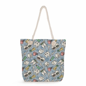Nurse themed tote bag with cartoon tooth print and white rope handles on blue canvas
