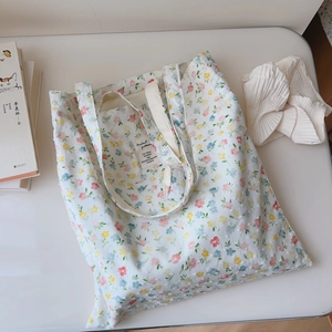 Detailed view of the floral tote bag's inner label and delicate cotton fabric texture
