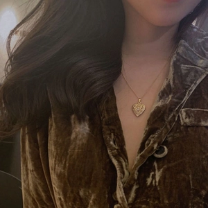 Golden heart locket necklace with white pearl and hollow design worn on model
