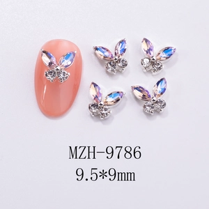 Macro detail of silver butterfly nail charms with iridescent rhinestones and 9.5x9mm size