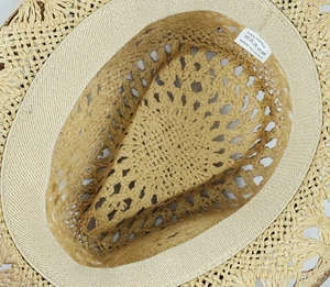 Detailed macro view of the interior woven paper fiber texture and sweatband of the cowboy hat