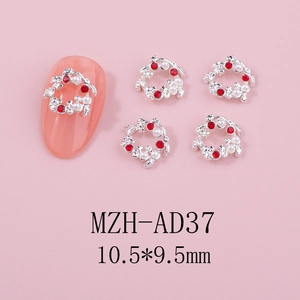 Détails de bijoux à ongles de Noël avec strass rouges et perles sur base argentée