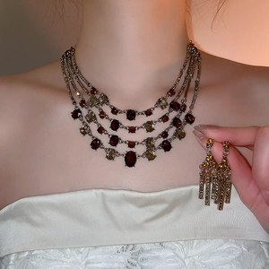 Macro view of vintage jewelry set with multi-layer necklace and tassel earrings