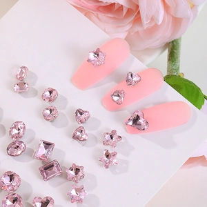 Close-up of assorted pink nail rhinestones in heart, star, and oval shapes on tips