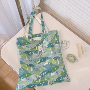 Macro shot of canvas tote bag featuring fresh rabbit and floral illustration with hair accessories
