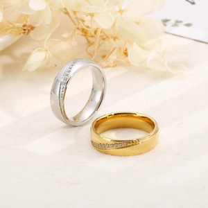 Detail of 6mm stainless steel couple rings with small diamonds on warm linen background