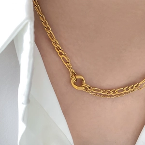 Close-up of golden double-layered titanium steel necklace with figaro and snake chain