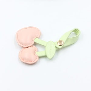Detailed view of pink and green cherry PU leather cord organizer with gold metal snap