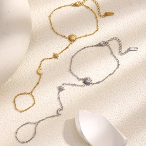 Bracelet bague en or 18 carats et argent avec breloques soleil et lune sur pierre texturée
