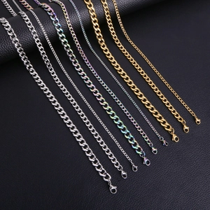 Multiple Cuban link chains in gold, silver, and multicolor displayed on black leather