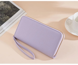 Detailed view of purple pebble-grain PU leather wallet with gold zipper and wrist strap
