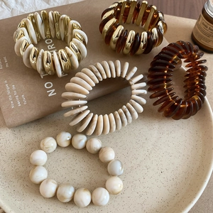 Detailed set of acrylic stretch bracelets with marble patterns and gold accents