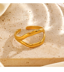 Close-up of golden lip-shaped ring on beige stone background with silk fabric