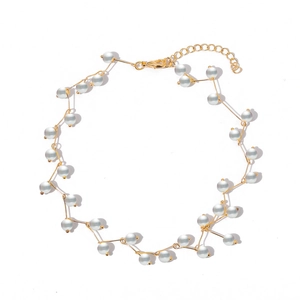 Minimalist gold-plated branch necklace with grey-white pearls on a clean white background