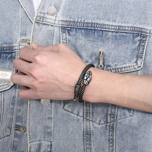 Close-up of matte black steel snake head cable bracelet on a male model wearing denim