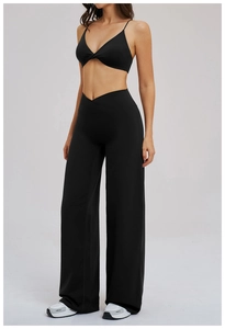 Close-up of women's black yoga set featuring V-shape cross waistband and knotted sports bra