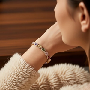 Close-up of vintage gold bracelet featuring colorful oval gemstones and pave-set zircons