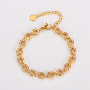 Detailed macro view of infinity symbol gold bracelet with cubic zirconia inlay stones