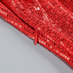 Macro shot of red sequin fabric detail and invisible zipper on sexy formal dress